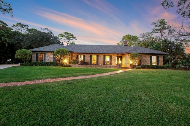 ranch-style home with a yard