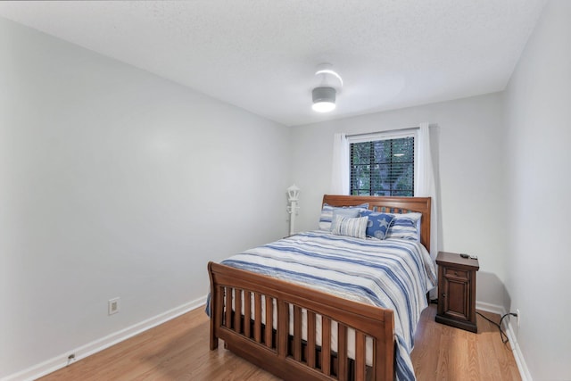 bedroom featuring a textured ceiling and light wood-type flooring