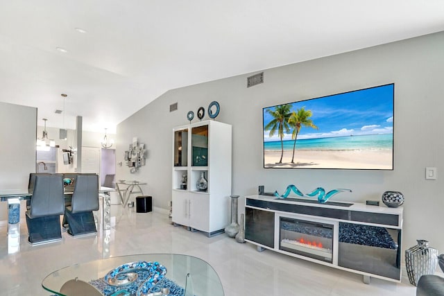 living room featuring vaulted ceiling and a notable chandelier