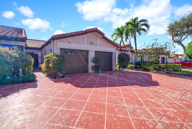 6140 Kings Gate Cir, Delray Beach, FL 33484 - view of front of property featuring a tiled roof, stucco siding, an attached garage, and driveway