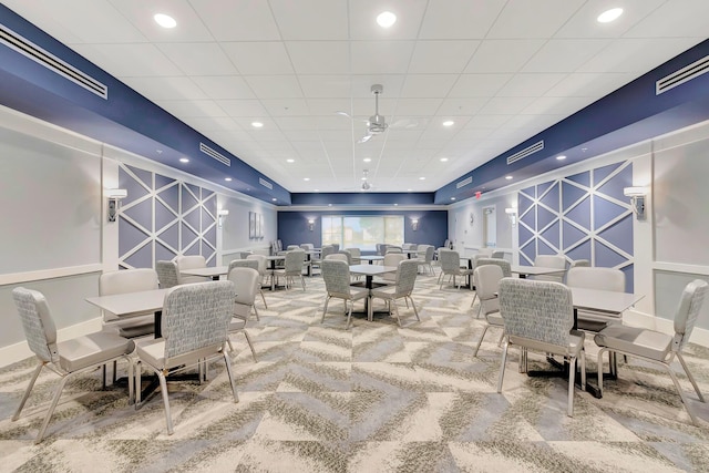 carpeted dining space with ceiling fan