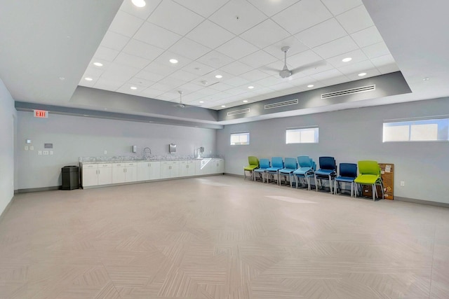 exercise room with ceiling fan, a wealth of natural light, and sink