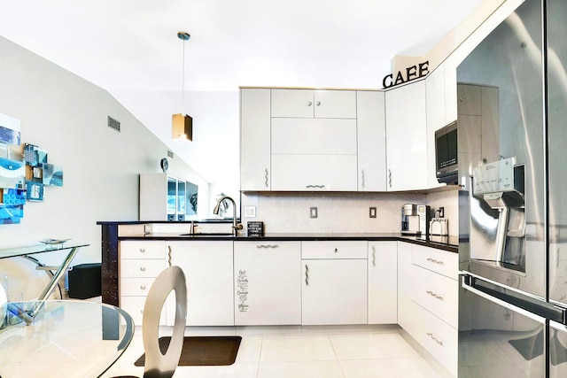 6140 Kings Gate Cir, Delray Beach, FL 33484 - kitchen featuring stainless steel appliances, a sink, dark countertops, light tile patterned flooring, and white cabinets
