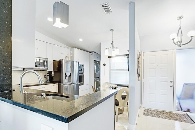 6140 Kings Gate Cir, Delray Beach, FL 33484 - kitchen featuring stacked washer and clothes dryer, a chandelier, stainless steel appliances, a sink, and light tile patterned floors