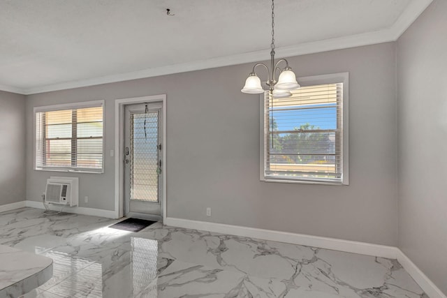 spare room featuring a wall unit AC, a notable chandelier, and crown molding