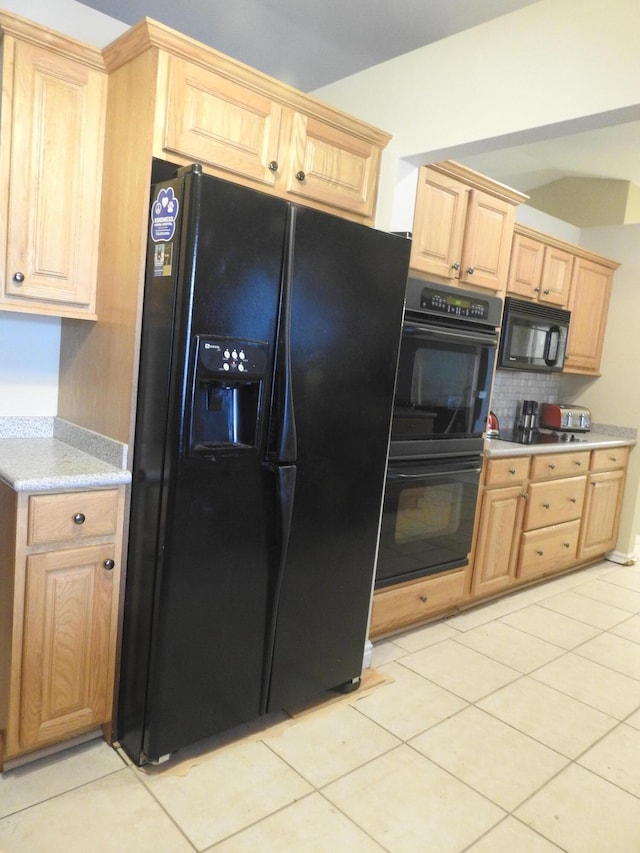 kitchen featuring light tile patterned flooring, light brown cabinets, decorative backsplash, and black appliances