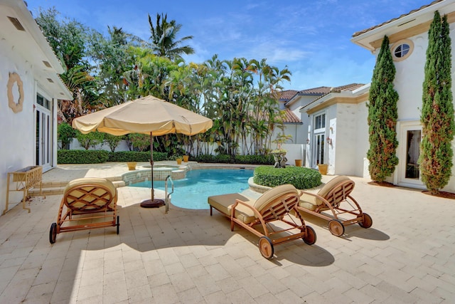 view of swimming pool with a patio and a pool with connected hot tub