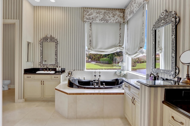 full bathroom with a garden tub, vanity, toilet, wallpapered walls, and tile patterned floors