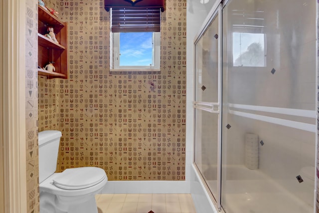 bathroom with toilet, combined bath / shower with glass door, and tile patterned flooring