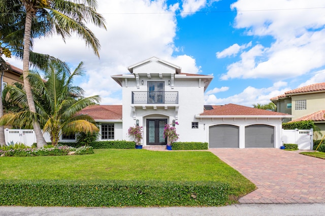 view of front of property with a front yard, french doors, and a balcony