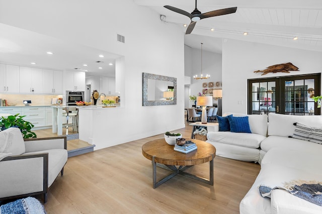 living room featuring vaulted ceiling with beams, wood ceiling, ceiling fan with notable chandelier, and light wood-type flooring