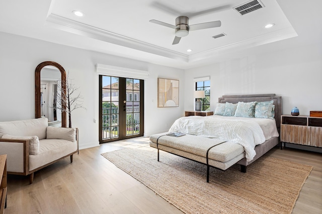 bedroom featuring french doors, access to outside, a raised ceiling, and ceiling fan