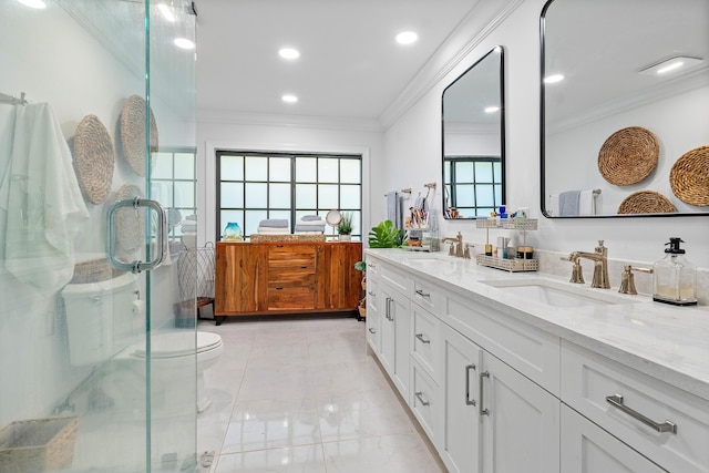 bathroom featuring vanity, toilet, ornamental molding, and a shower with door