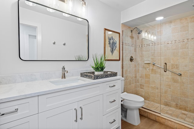 bathroom with hardwood / wood-style floors, vanity, toilet, and walk in shower