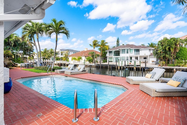 view of pool featuring a water view and a patio