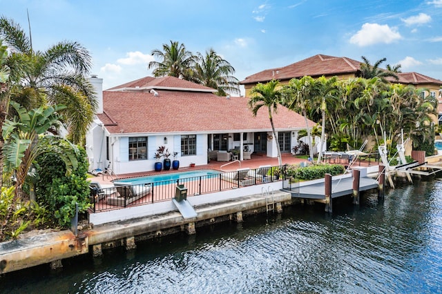 back of house featuring a water view and a patio