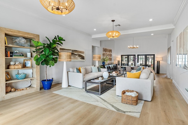 living room with light hardwood / wood-style floors, crown molding, and a chandelier