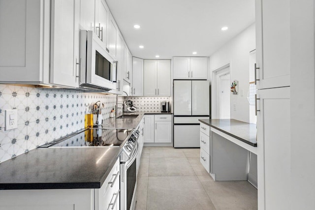 kitchen featuring white cabinets, white appliances, sink, and tasteful backsplash