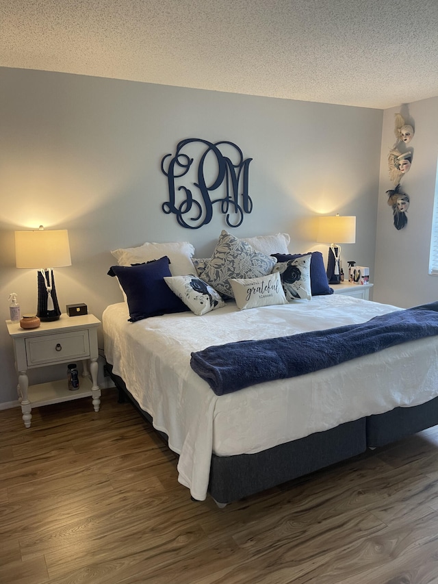 bedroom featuring dark hardwood / wood-style flooring and a textured ceiling