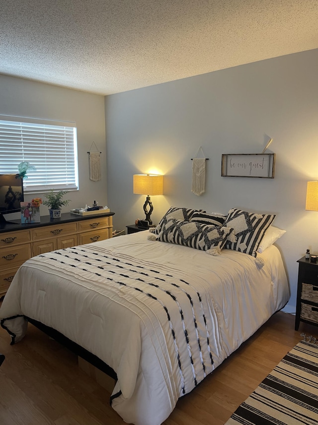 bedroom featuring a textured ceiling and hardwood / wood-style flooring