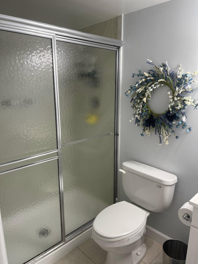 bathroom featuring toilet, tile patterned flooring, and walk in shower