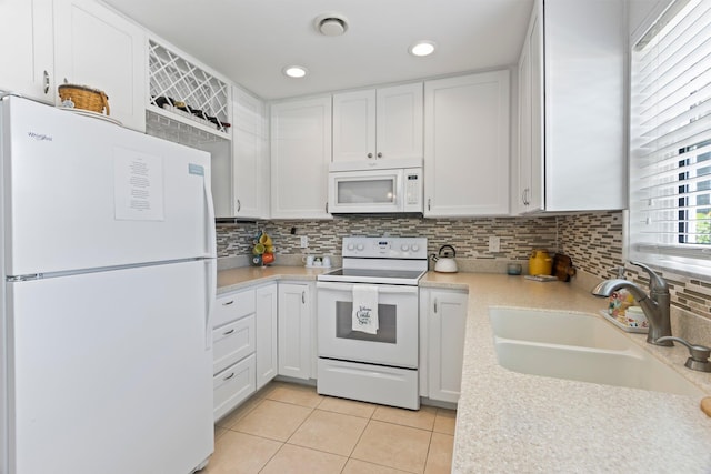 kitchen featuring light tile patterned flooring, white appliances, white cabinetry, and sink