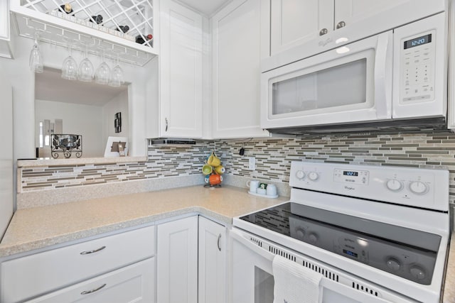 kitchen with decorative backsplash, white cabinets, and white appliances