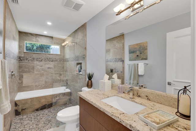 bathroom with toilet, a tile shower, and vanity