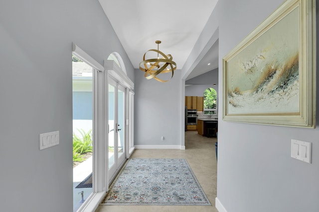 doorway to outside featuring a notable chandelier and french doors