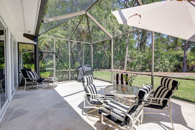 view of patio with glass enclosure and area for grilling