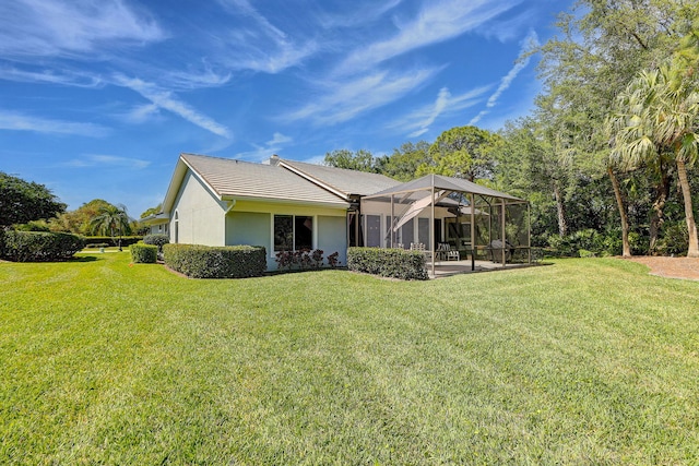 back of property featuring a lanai and a lawn