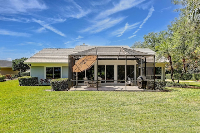 rear view of property featuring a lawn, a patio area, and a lanai