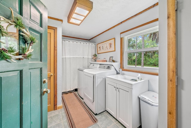 washroom with washer and dryer, cabinets, ornamental molding, and a textured ceiling