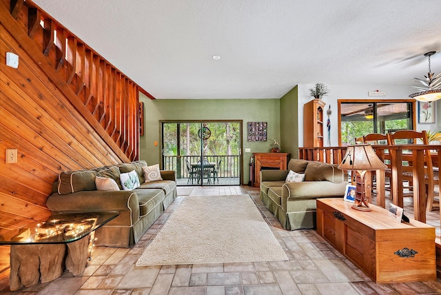 living room featuring wood walls and a textured ceiling