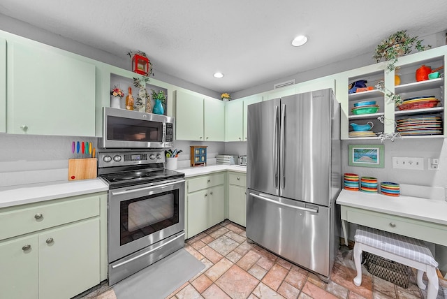 kitchen with a textured ceiling, stainless steel appliances, and green cabinets