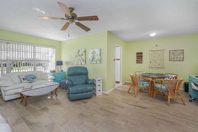 living room featuring ceiling fan and a textured ceiling