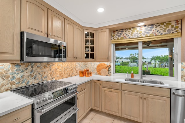 kitchen with light brown cabinetry, appliances with stainless steel finishes, light tile patterned floors, sink, and backsplash