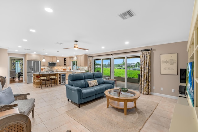 tiled living room featuring ceiling fan, beverage cooler, and crown molding