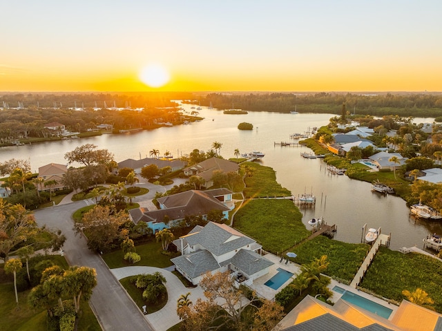 aerial view at dusk featuring a water view