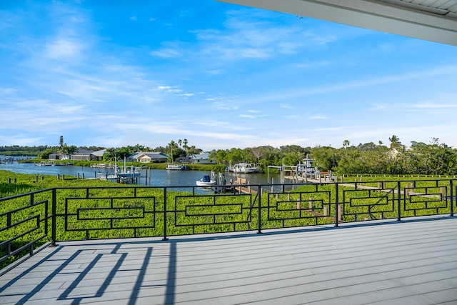 wooden terrace featuring a lawn and a water view