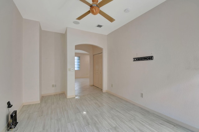 empty room with ceiling fan and light tile patterned floors