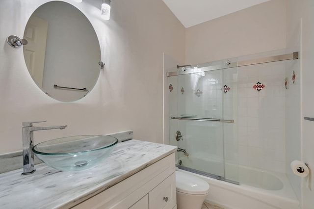 full bathroom featuring vanity, toilet, and bath / shower combo with glass door