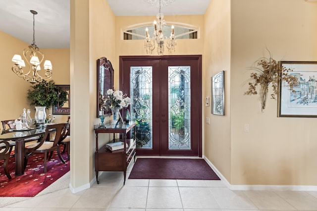 foyer featuring light tile patterned floors, french doors, and a notable chandelier