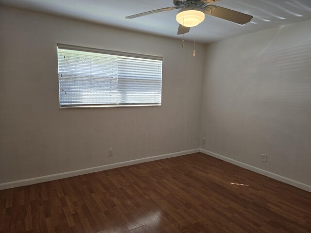 empty room with ceiling fan and dark wood-type flooring