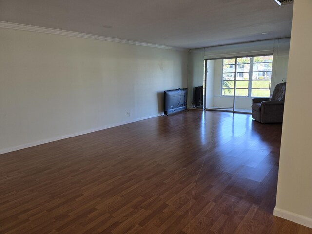 unfurnished living room with dark hardwood / wood-style floors and ornamental molding