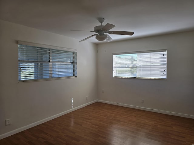 spare room with dark hardwood / wood-style flooring and ceiling fan