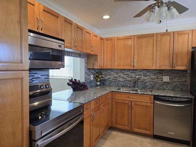 kitchen with sink, dark stone countertops, crown molding, decorative backsplash, and appliances with stainless steel finishes