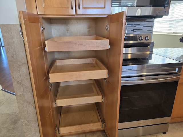 details featuring decorative backsplash and stainless steel range oven