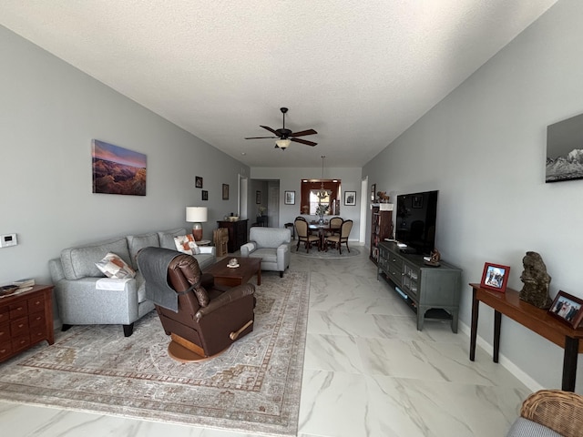 living room with ceiling fan and a textured ceiling