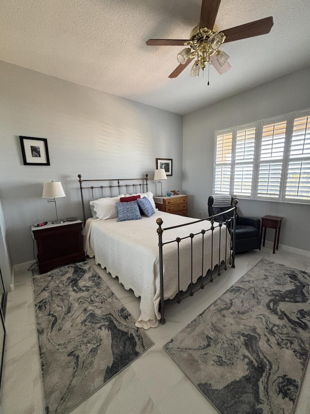 bedroom featuring ceiling fan and a textured ceiling